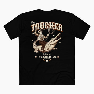 Black t-shirt with a graphic of a cowboy and alligator, and text 'I'm Tougher Than a Two Dollar Steak' on a white background.