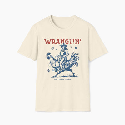 Beige t-shirt with a graphic of a cowboy and rooster and the word 'WRANGLIN' on a white background.